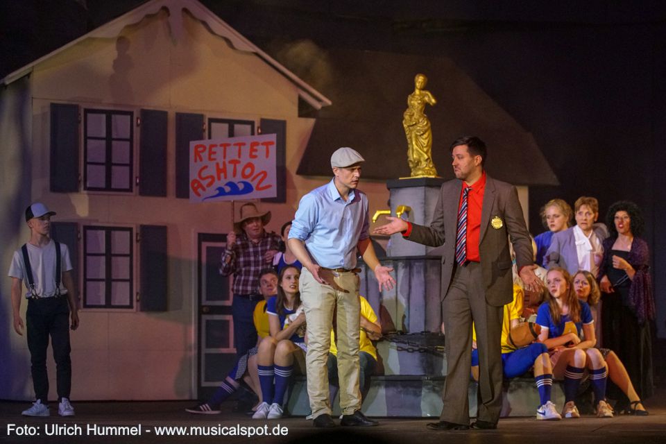 Edward hat in der Zeitung vom neuen Staudamm gelesen und macht sich auf, um die Stadt noch einmal zu sehen. Dass hier noch Leute sind, überrascht ihn, denn der Damm, gegen den in Ashton noch protestiert wird, ist längst gebaut. Das Wasser steigt bereits. „Weiß eigentlich jemand, dass ihr noch hier seid?“ fragt er. Logisch. Bürgermeister Price ist sicher. Naja, jedenfalls, bis er mal drüber nachdenkt. big fish musical leinfelden 184